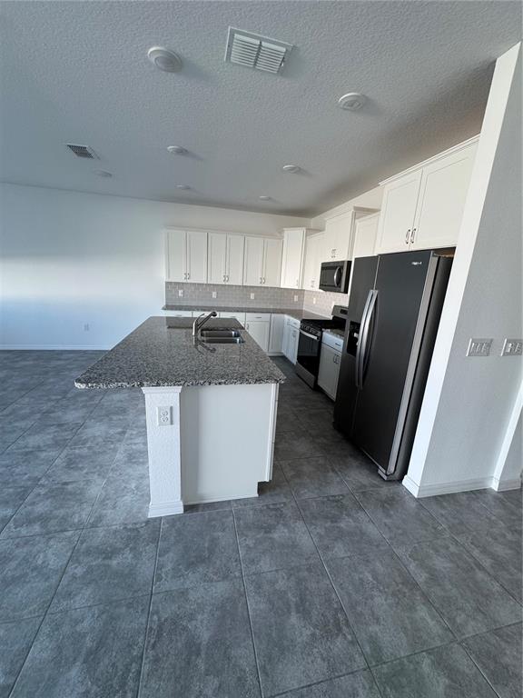 6425 Southwest 78th Ave Road Ocala, FL 34474 - Photo 7 of 13 a kitchen with refrigerator and microwave