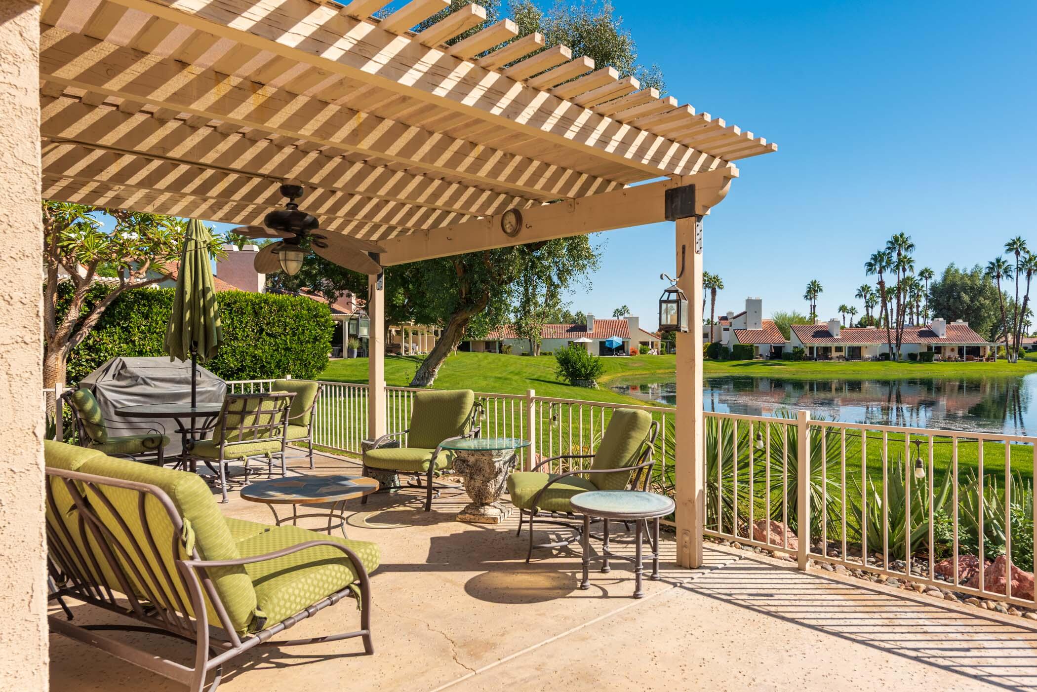 345 Forest Hills Drive Rancho Mirage, CA 92270 - Photo 3 of 37 a view of a chairs and table in patio with a lake view