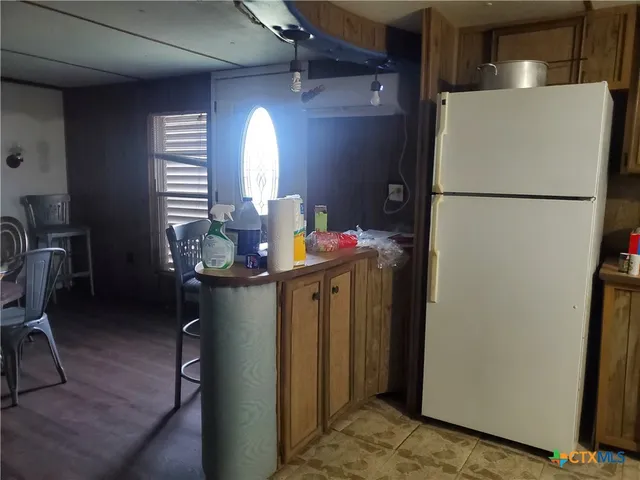 a hallway with chairs and a refrigerator
