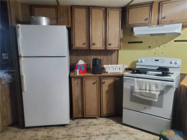 a kitchen with stainless steel appliances granite countertop a refrigerator and a stove