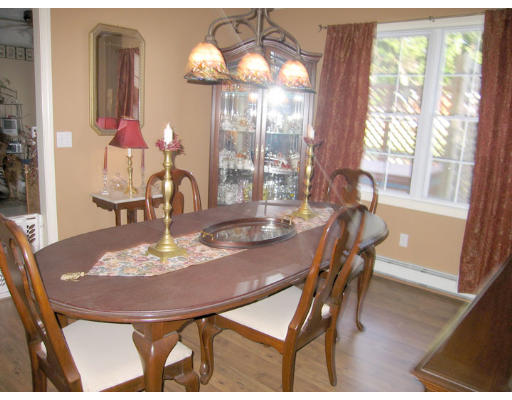 140 Cleveland Street Woonsocket, RI 02895 - Photo 10 of 26 a dining room with wooden floor a chandelier a wooden table and chairs