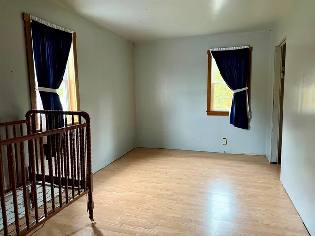 a view of a hallway with wooden floor and windows