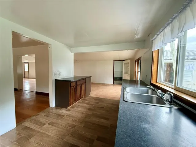 a view of a kitchen with stainless steel appliances granite countertop a sink and a counter top space