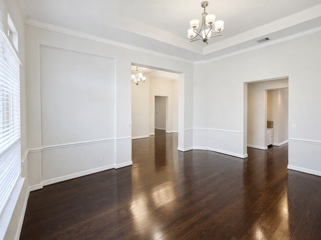 10407 Roseate Skimmer Conroe, TX 77385 - Photo 14 of 30 an empty room with wooden floor chandelier and windows