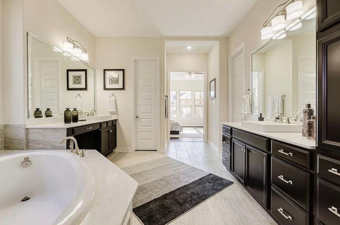 10407 Roseate Skimmer Conroe, TX 77385 - Photo 15 of 30 a en suite bathroom with a tub sink and mirror