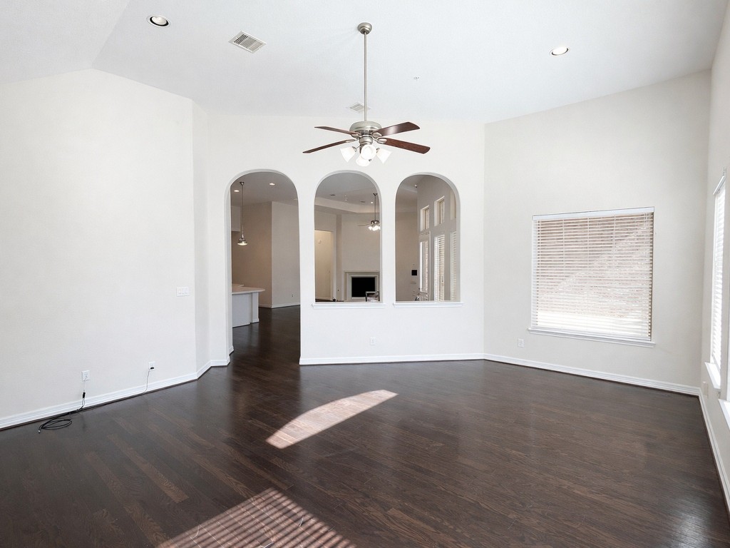 10407 Roseate Skimmer Conroe, TX 77385 - Photo 20 of 30 an empty room with wooden floor chandelier fan and windows
