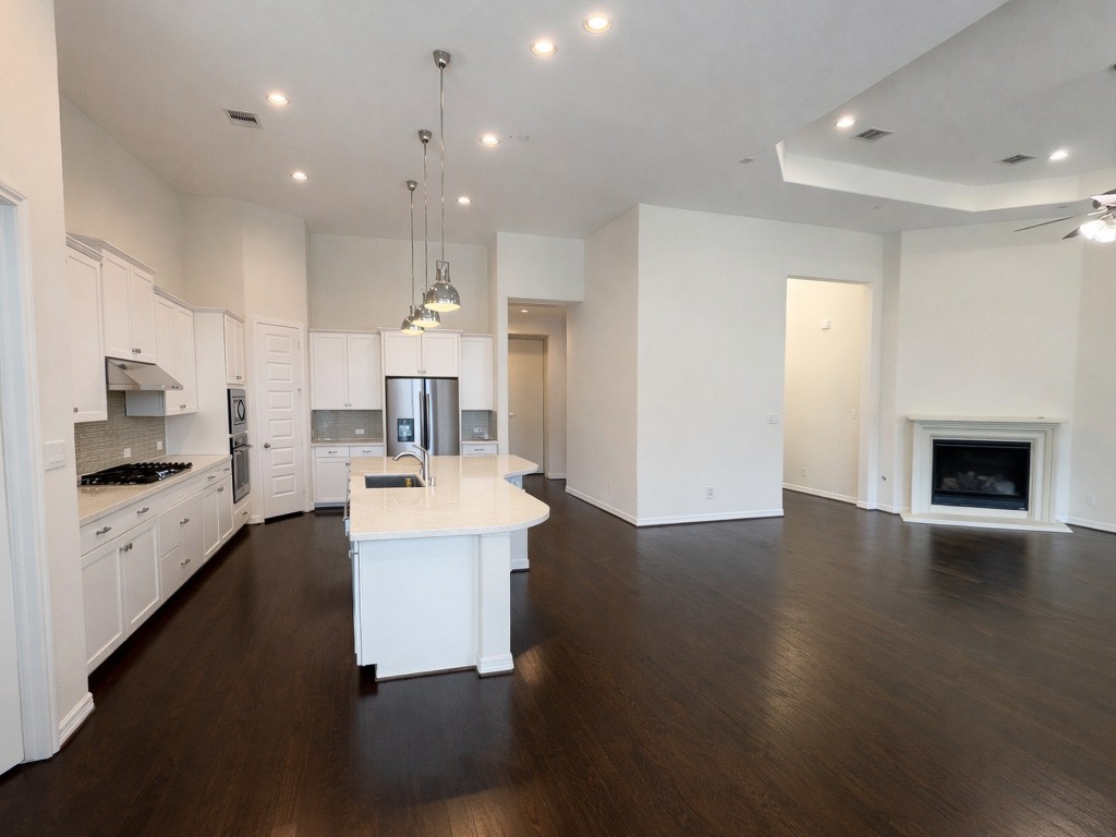 10407 Roseate Skimmer Conroe, TX 77385 - Photo 6 of 30 a large kitchen with a sink dishwasher a stove and a refrigerator with wooden floor
