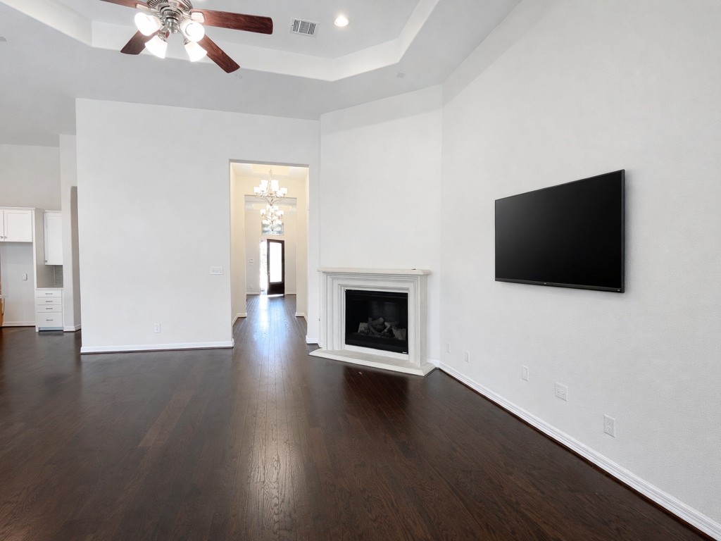 10407 Roseate Skimmer Conroe, TX 77385 - Photo 9 of 30 a view of a livingroom with a flat screen tv a fireplace and wooden floor