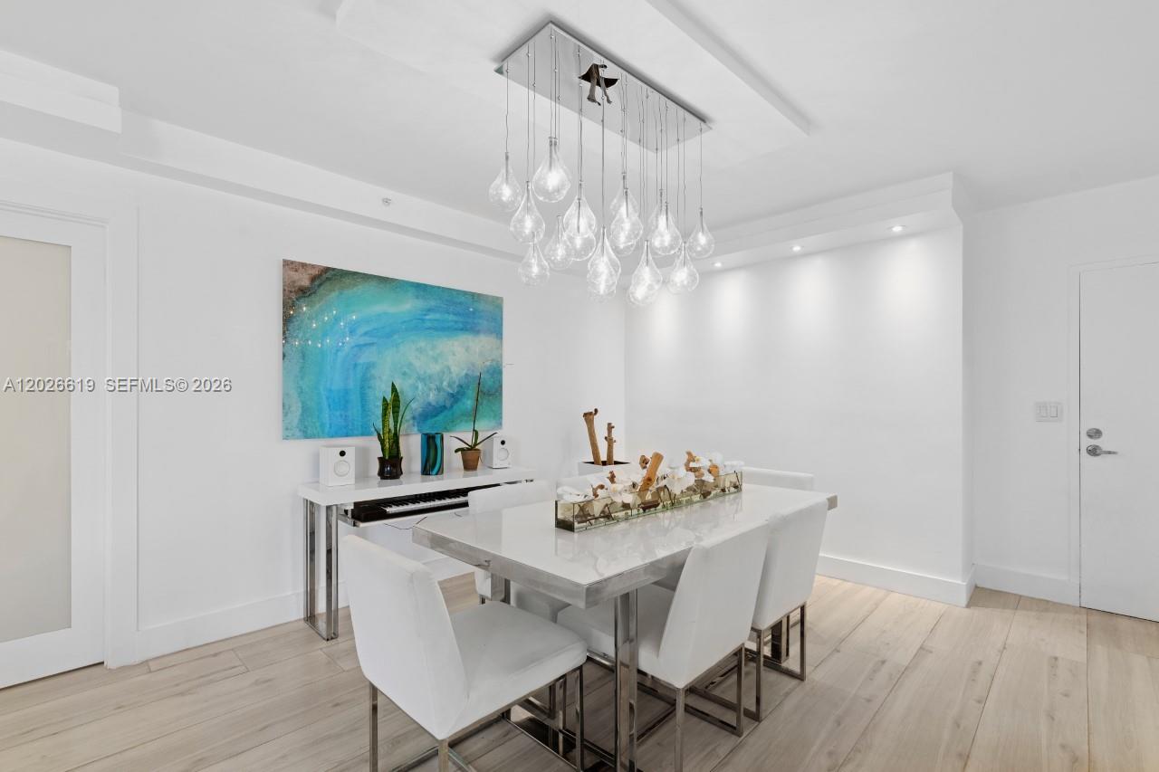1500 Bay Road, Unit 1268S Miami Beach, FL 33139 - Photo 8 of 31 a dining room with furniture a chandelier and wooden floor