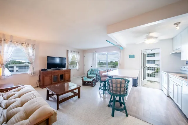 a living room with furniture a flat screen tv and a large window