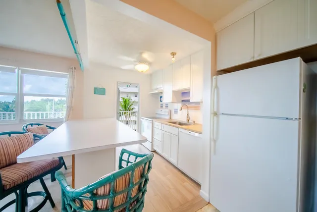 a kitchen with stainless steel appliances a refrigerator a stove a sink a dining table and chairs