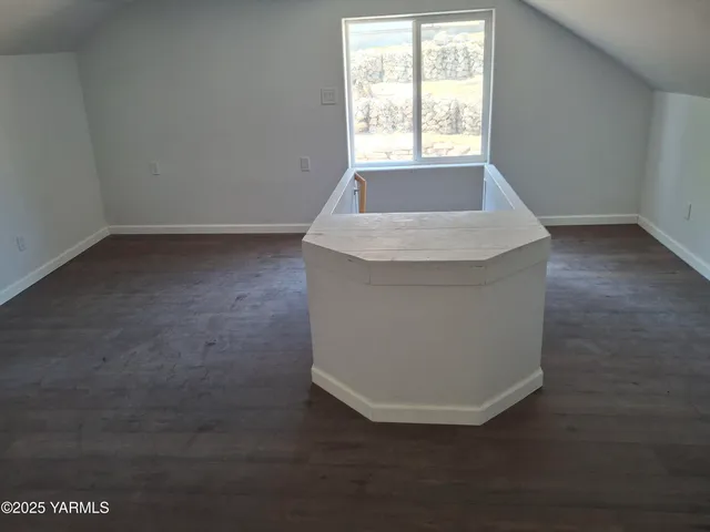 a view of wooden floor and window in an empty room