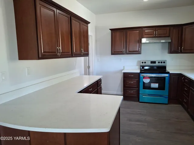 a kitchen with wooden cabinets and a stove top oven