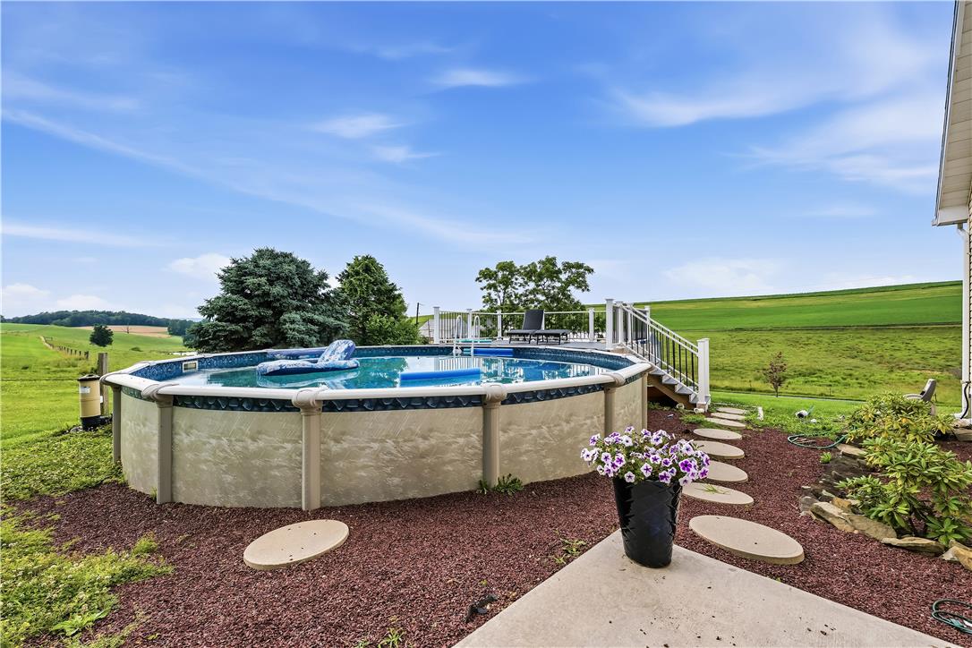 9868 Stagecoach Road Kempton, PA 19529 - Photo 17 of 17 An inviting above-ground pool and deck offer panoramic views of rolling green hillsides.