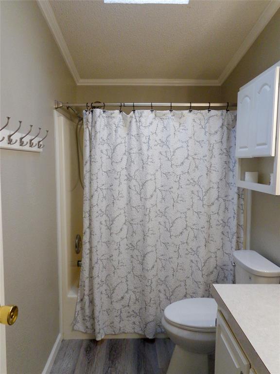 5525 Cedar Oaks Road Grandview, TX 76050 - Photo 20 of 40 Bathroom featuring a shower-tub combination, wood-finish flooring, and crown molding