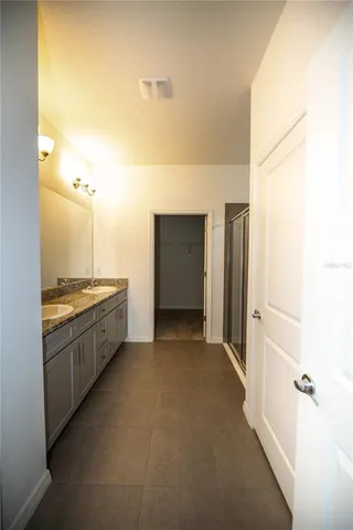 a view of a bathroom with mirror and shower