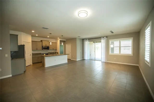 a large kitchen with granite countertop a large counter top stainless steel appliances and cabinets
