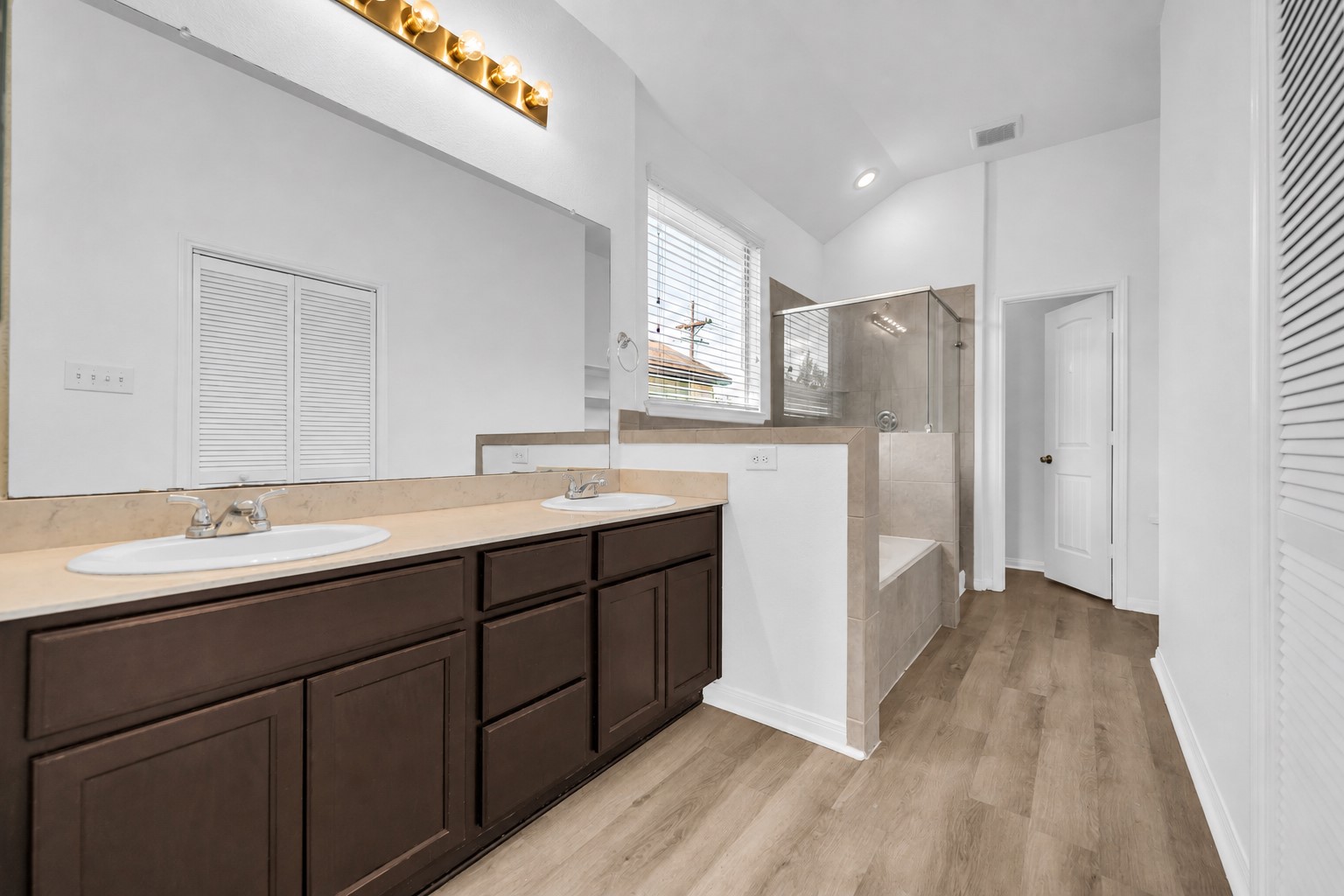 4707 Waukegan Road Conroe, TX 77306 - Photo 20 of 31 Primary bathroom features a double-sink vanity, a separate shower, and a soaking tub, providing a practical and comfortable space for daily routines.