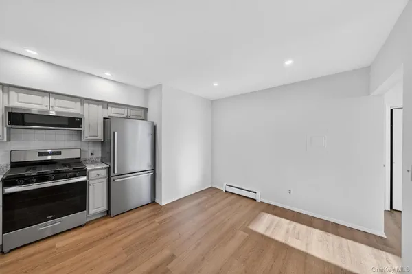 a kitchen with wooden floors and stainless steel appliances