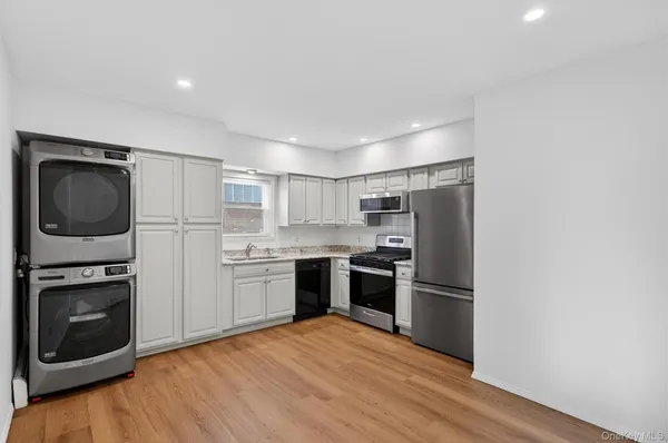 a kitchen with a refrigerator stove and wooden floor