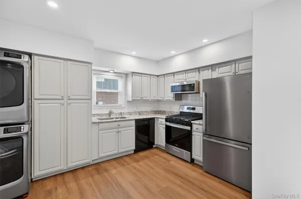 a kitchen with stainless steel appliances granite countertop a refrigerator stove and microwave