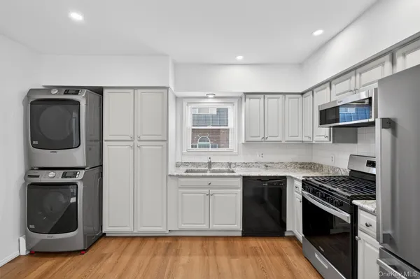 a kitchen with stainless steel appliances granite countertop a stove a sink and a refrigerator