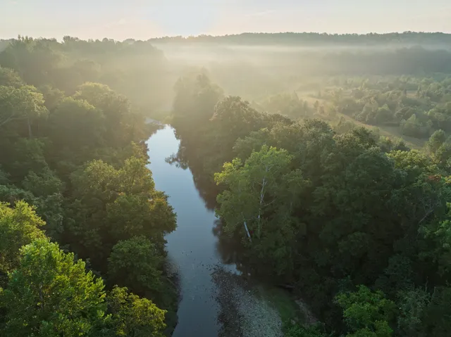 a kitchen with kitchen island granite countertop a sink cabinets and stainless steel appliances