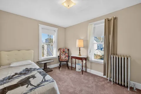 a spacious bedroom with a bed a table and windows