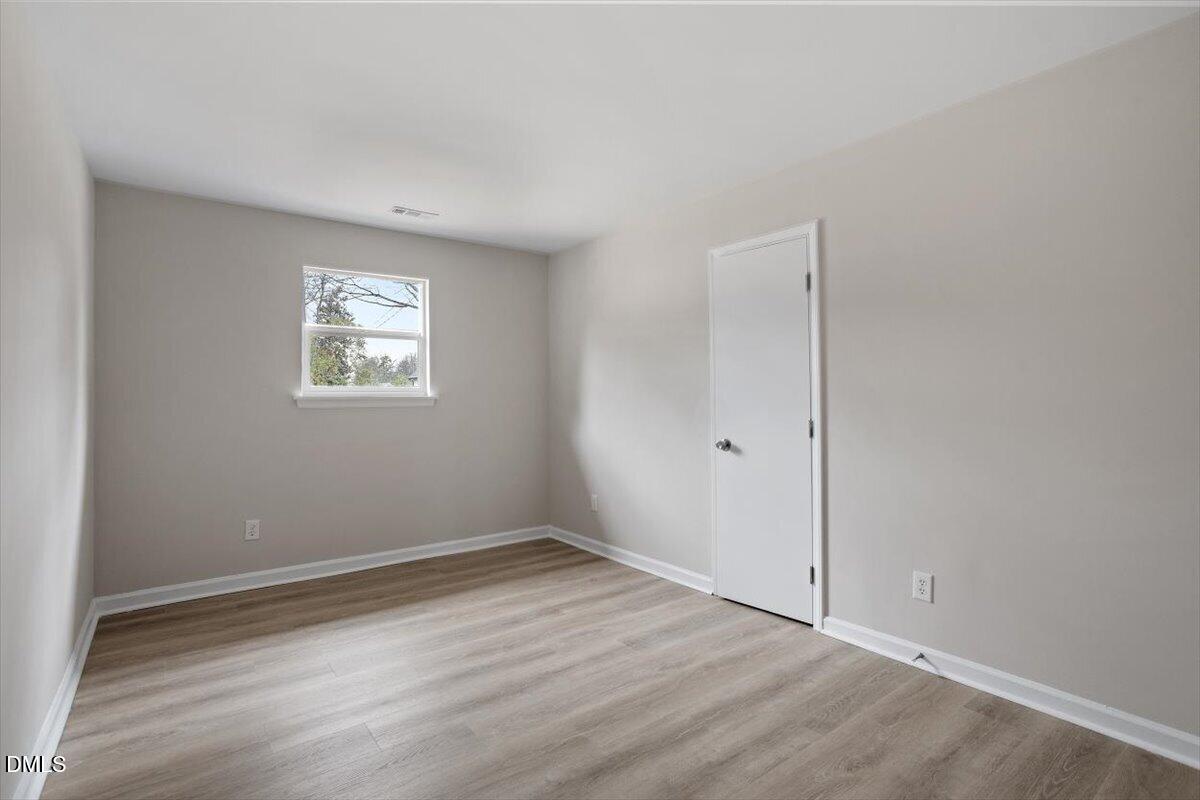 3306 Prudence Street Durham, NC 27704 - Photo 17 of 22 a view of an empty room with wooden floor and a window