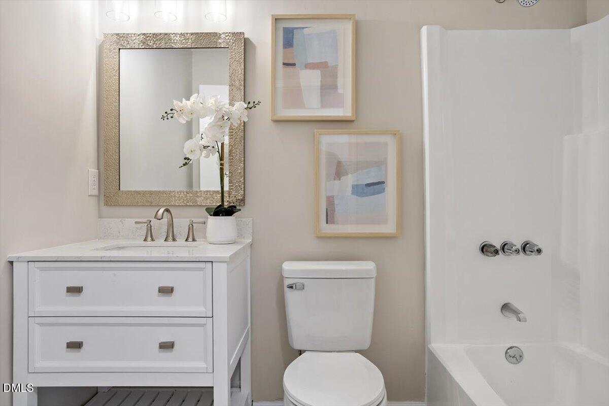 3306 Prudence Street Durham, NC 27704 - Photo 19 of 22 a bathroom with a toilet a sink and mirror