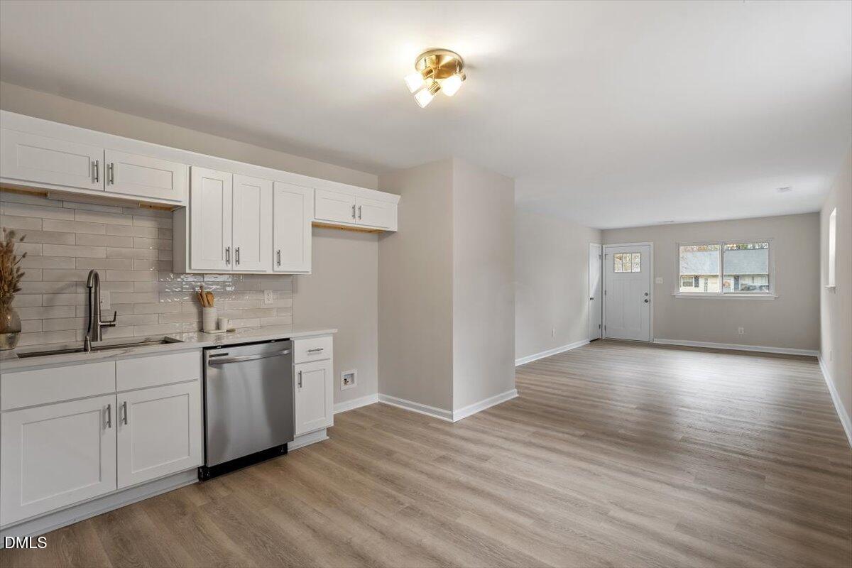 3306 Prudence Street Durham, NC 27704 - Photo 7 of 22 a kitchen with stainless steel appliances granite countertop a dishwasher a stove with wooden floor and cabinets
