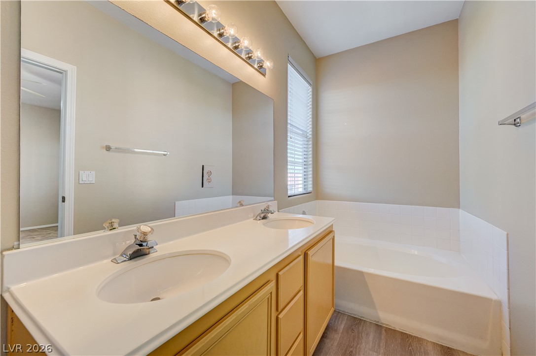 2232 Ramsgate Drive Henderson, NV 89074 - Photo 15 of 19 An integrated vanity countertop and a soaking tub complete this functional bathroom space.