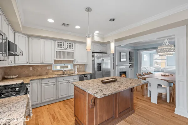 a kitchen with stainless steel appliances granite countertop white cabinets and a stove top oven