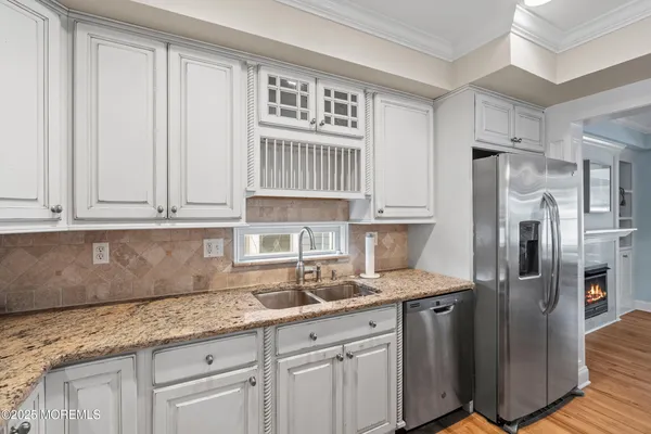 a kitchen with stainless steel appliances granite countertop a refrigerator stove top oven and sink