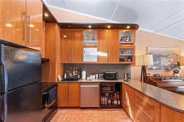 a kitchen with stainless steel appliances granite countertop a refrigerator a stove and a sink with wooden floor
