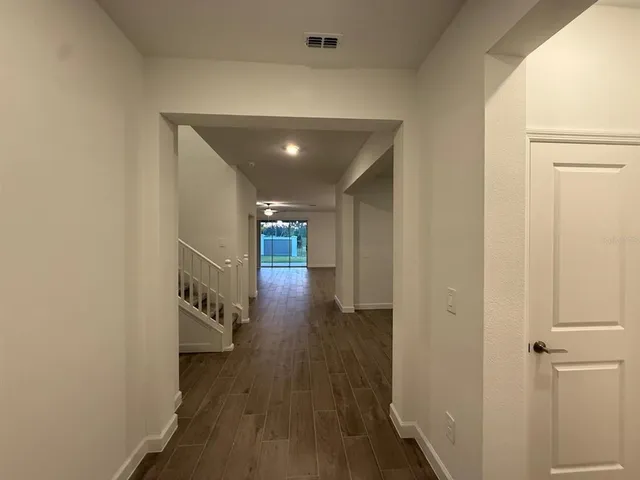 a view of hallway with wooden floor