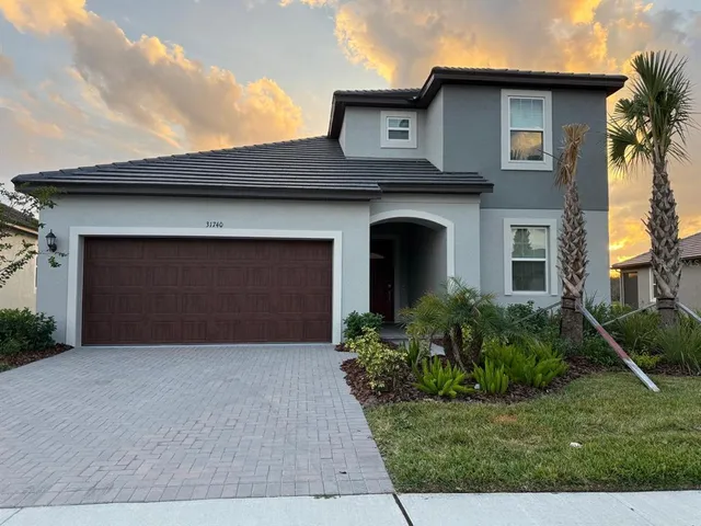 a front view of a house with a yard and garage
