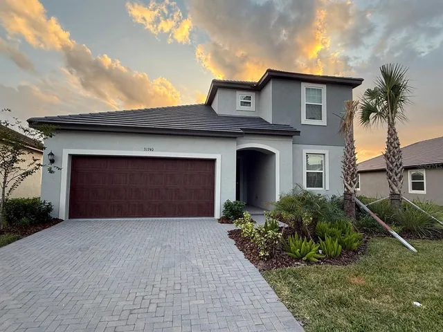 a front view of a house with a garden and garage