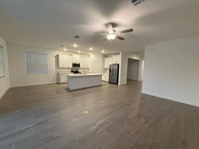 a view of a kitchen with a sink a ceiling fan and refrigerator