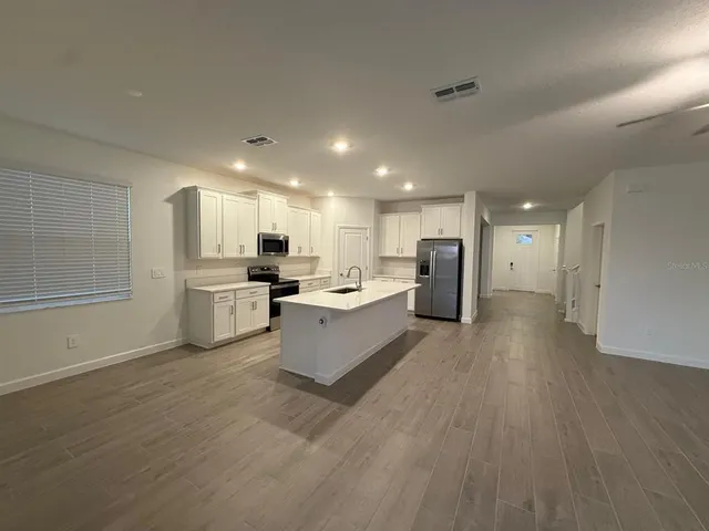 a large kitchen with a lot of counter space and stainless steel appliances