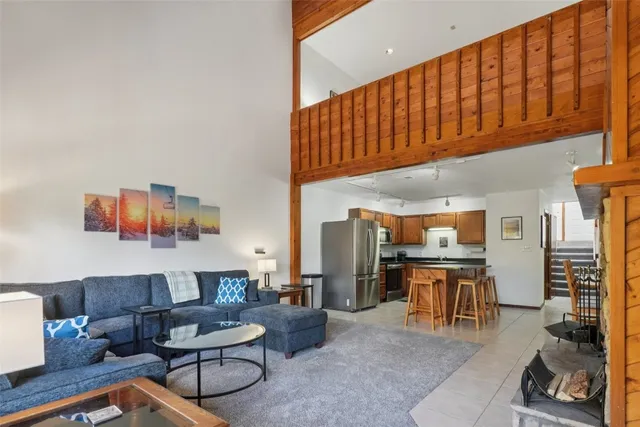 a living room with furniture a rug and kitchen view