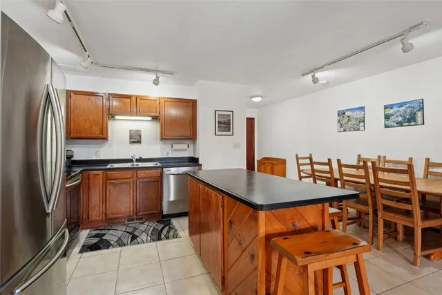 a kitchen with stainless steel appliances granite countertop a refrigerator and a stove top oven