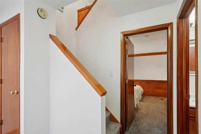 a view of staircase with railing and white walls