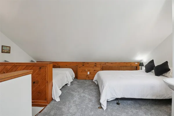 a large bed sitting in a bedroom next to a window