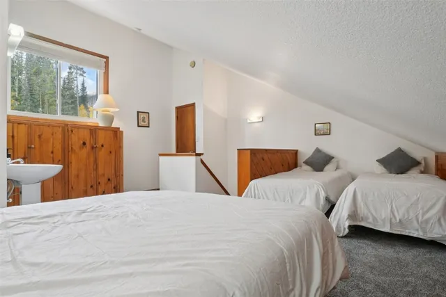 a large bed sitting in a bedroom next to a window