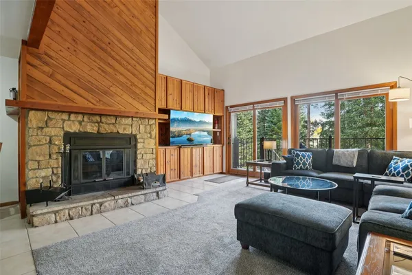 a living room with furniture large window and fireplace