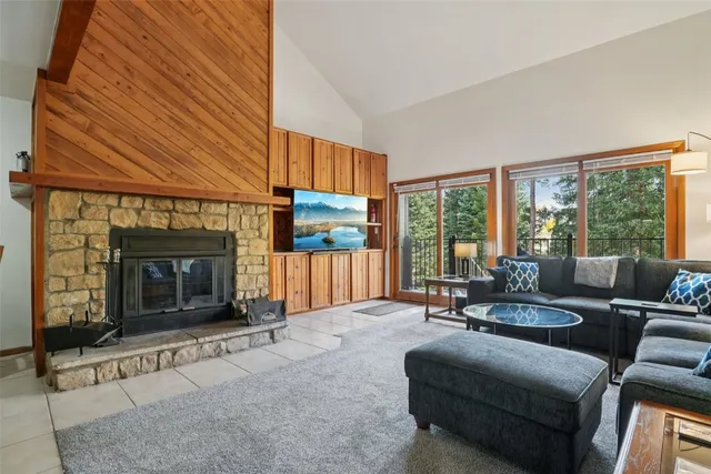 a living room with furniture large window and fireplace