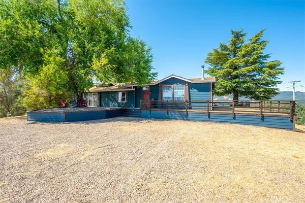 a front view of house with yard and trees in the background