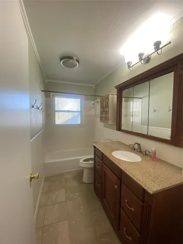 a bathroom with a granite countertop sink mirror and a toilet
