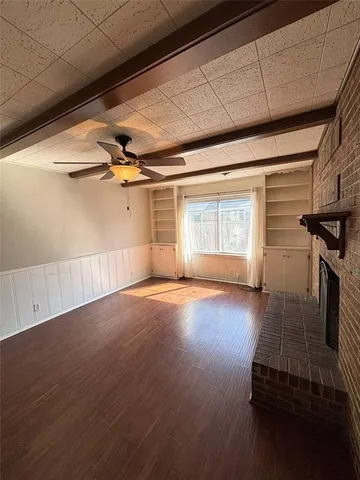 a view of a livingroom with wooden floor and a window